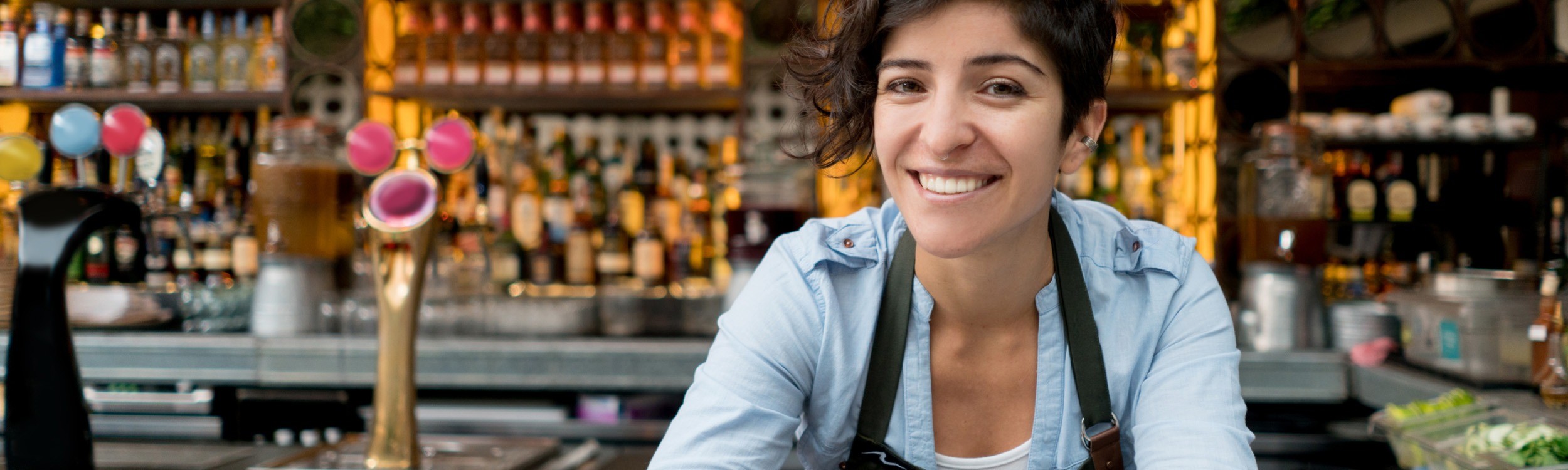 female smiling in fron of a bar
